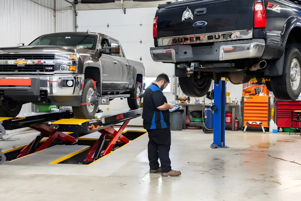 Preventative maintenance in Glen Rock, PA by Cain and Son’s Automotive. Image of a technician inspecting lifted Chevy and Ford trucks in the shop, showing the team’s commitment to reliable service, safety, and peak performance for heavy-duty vehicles.