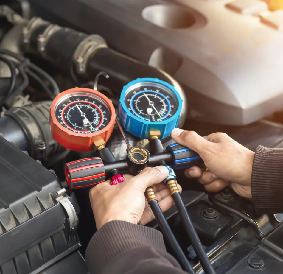 Cain and Sons’ Automotive technician in Glen Rock, PA using a manifold gauge set to check a car’s air conditioning system, ensuring proper performance and ADAS calibration support.