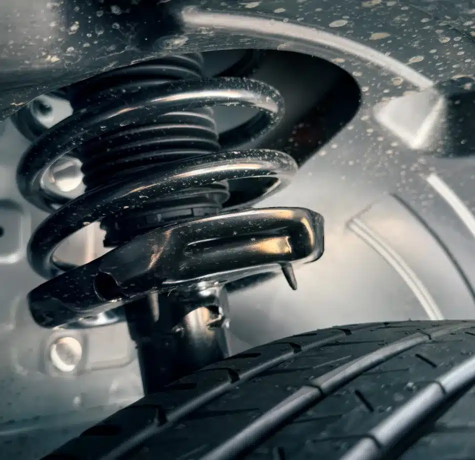 Detailed view of a car suspension system with coil spring and shock absorber at Cain and Sons’ Automotive in Glen Rock, PA, supporting ADAS stability and safety.