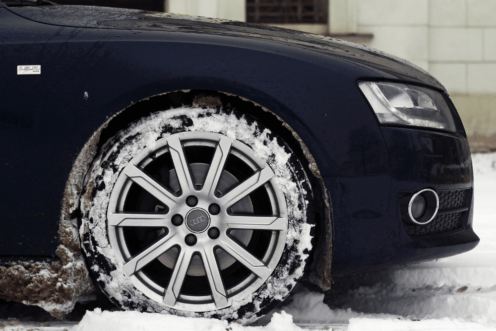 Salt rust prevention, auto repair in Glen Rock, PA by Cain and Sons' Automotive. Image of an Audi tire packed with snow on a winter road. Highlighting Cain and Sons' Automotive’s commitment to safe winter traction and reliable cold-weather performance.