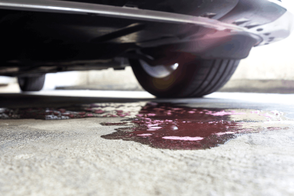 Car fluid leak, auto repair in Glen Rock, PA by Cain and Son’s Automotive. Image of red fluid leaking beneath a vehicle, indicating a serious automotive fluid leak that requires immediate professional inspection and repair to protect engine and transmission performance.