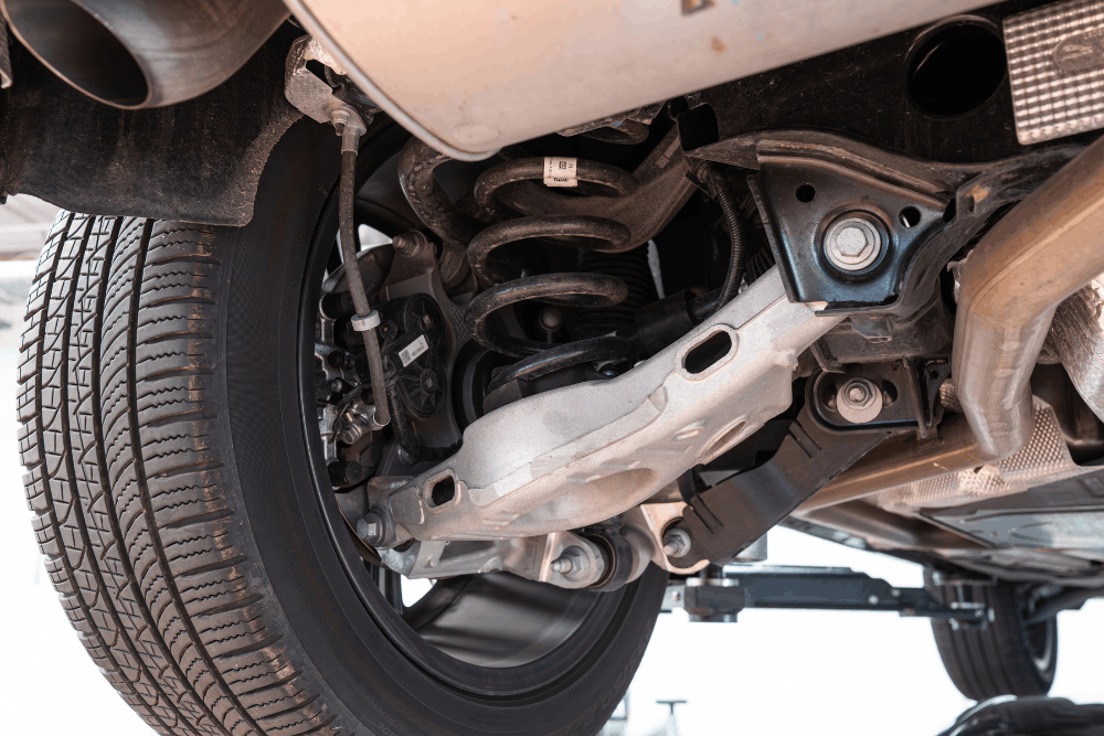 Shocks and struts replacement, auto repair in Glen Rock, PA, at Cain and Sons' Automotive. Image of vehicle rear suspension with coil spring, control arm, and wheel assembly, emphasizing safe handling and reliable ride performance.